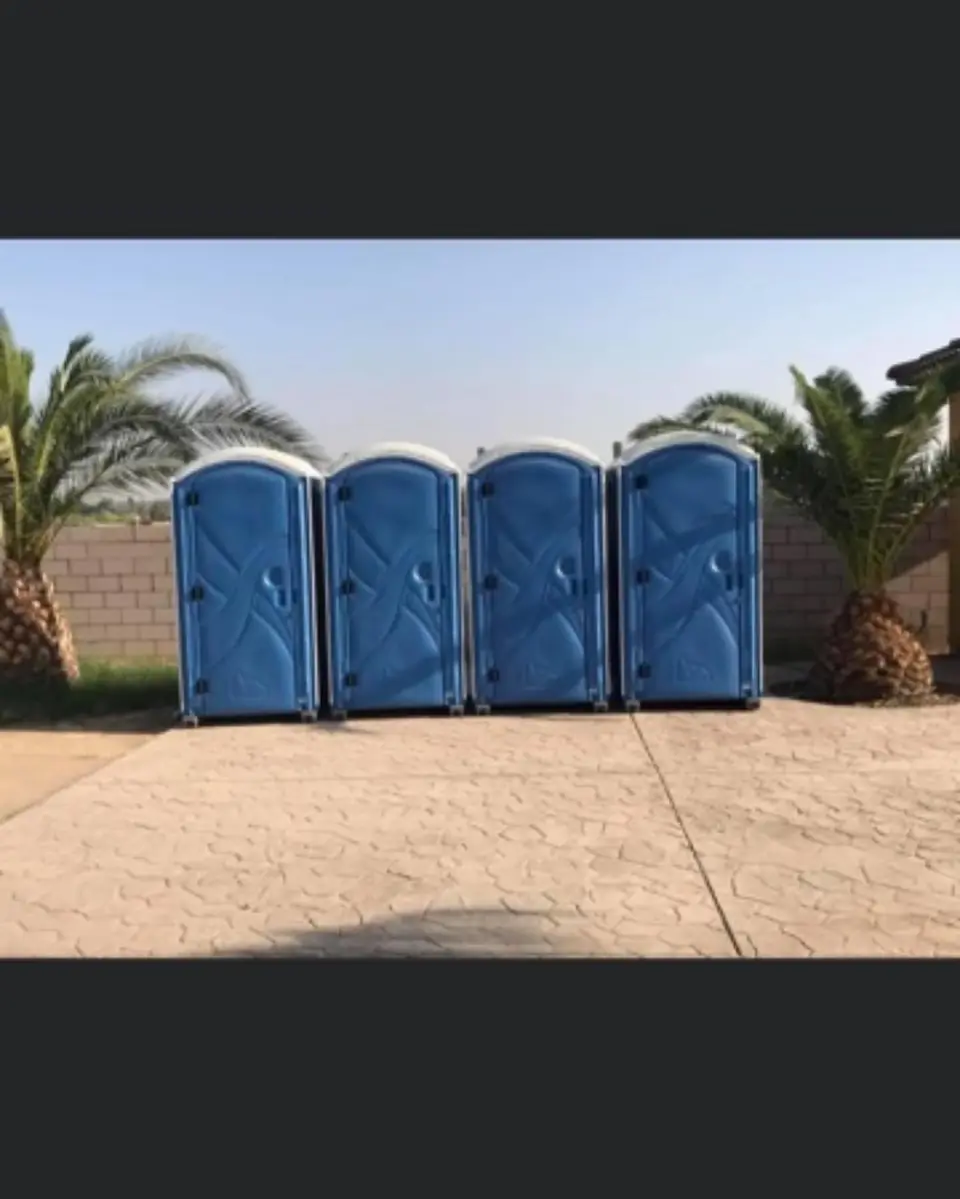 Four blue porta potties lined up for an event